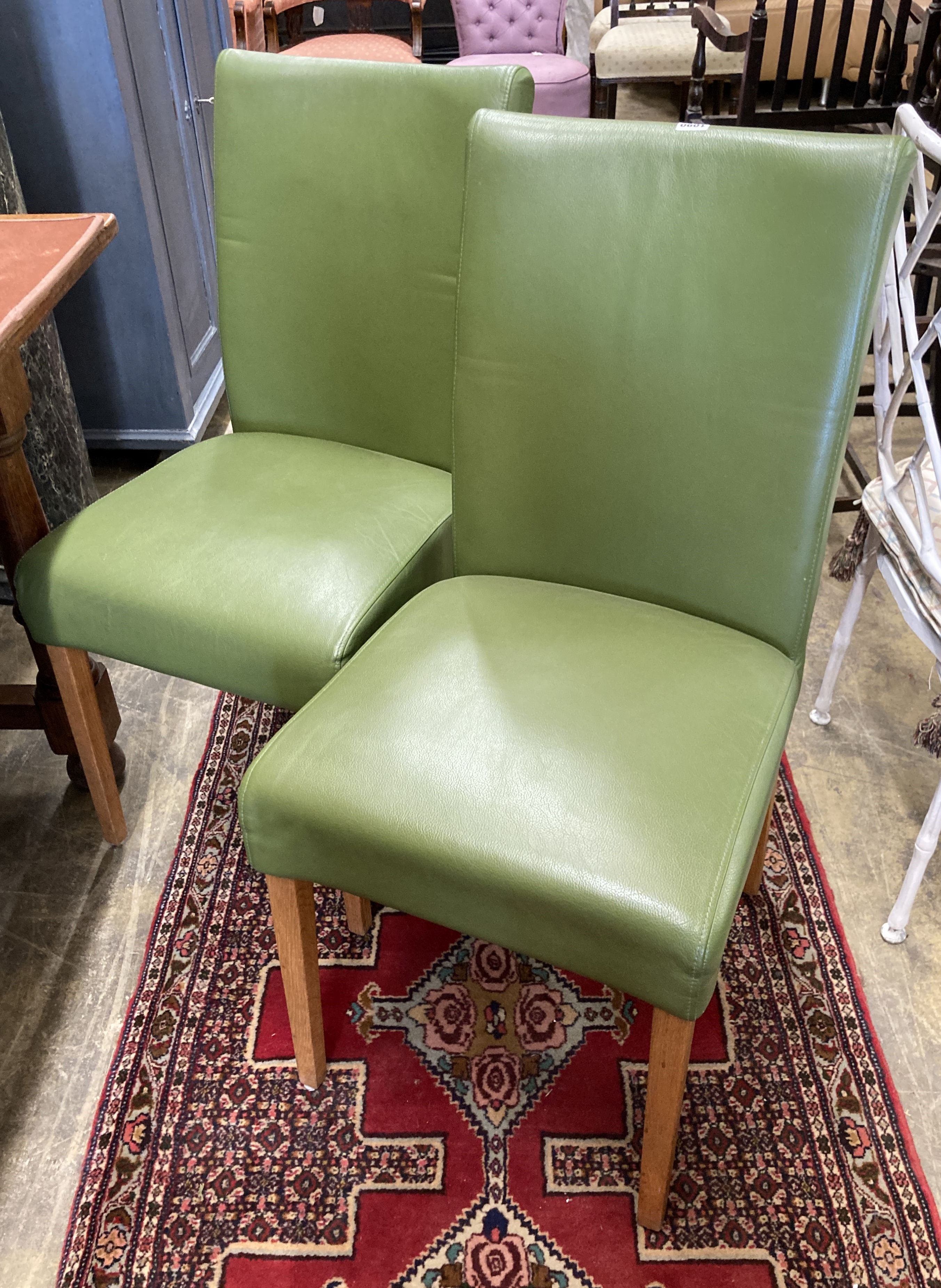 A set of eight contemporary oak and green leather dining chairs, width 45cm, depth 50cm, height 95cm